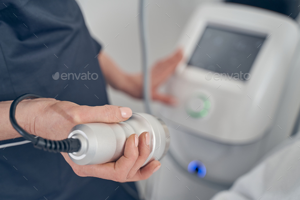 Modern tool for cavitation in hand of professional cosmetologist - Stock Photo - Images