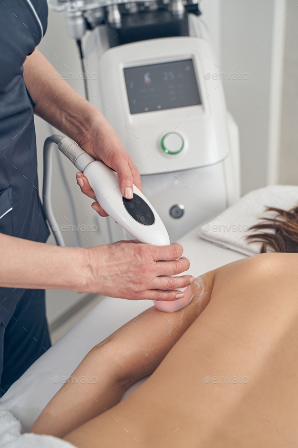 Woman getting modern cavitation treatment in beauty salon - Stock Photo - Images