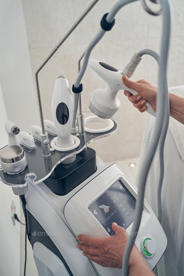Hands of beautician on the modern ultrasound cavitation machine - Stock Photo - Images