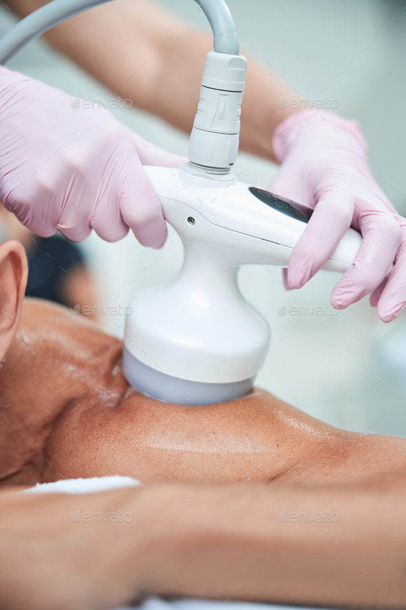 Aging man attending an ultrasonic cavitation session - Stock Photo - Images