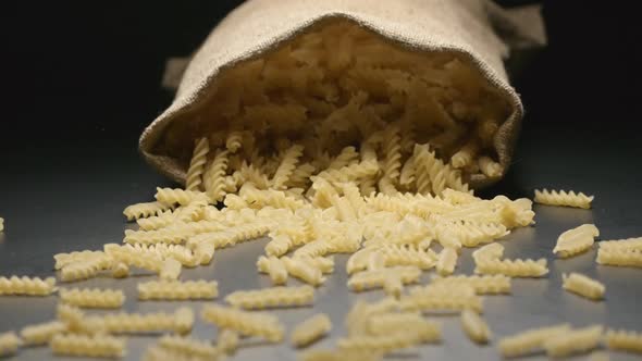 Cloth bag falls and pasta (fusilli) fall out of him