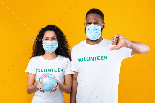 Volunteers Wearing Face Masks Holding Earth Globe Gesturing Thumbs-Down, Studio