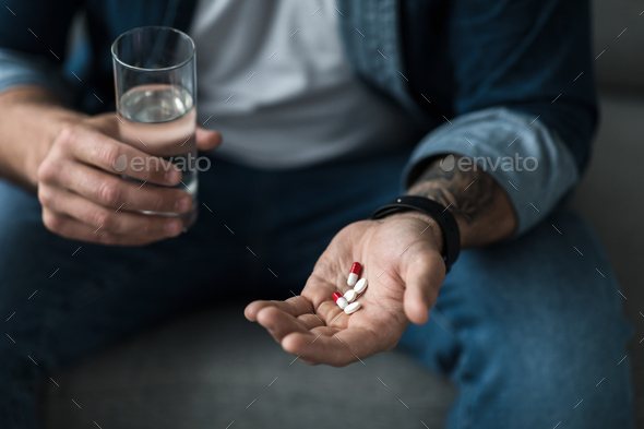Deeply unhappy, depressed man, suicide, taking somnifacient, antidepressant, overdose drug - Stock Photo - Images