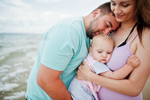 Father, pregnant mother, baby daughter on sea sand beach. Stock Photo ...