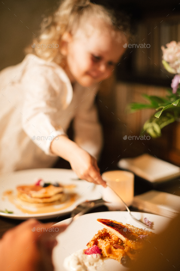 Parents with their curly daughter, having healthy meal together. Nutrition Concept. - Stock Photo - Images