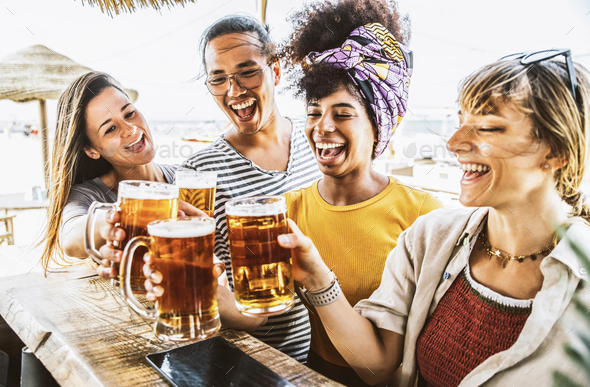 Happy multiracial friends toasting beer glasses at brewery pub Stock Photo  by engy91