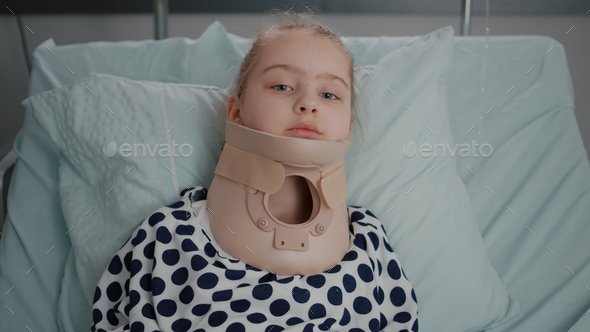 Portrait of sick little patient resting in bed looking at camera while having neck cervical collar
