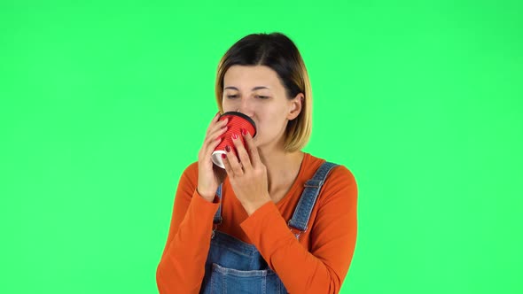 Cheerful Young Woman Enjoying Coffee on Green Screen alt