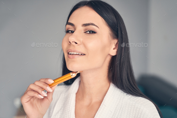 Contented beautiful Caucasian lady massaging her chin Stock Photo by ...