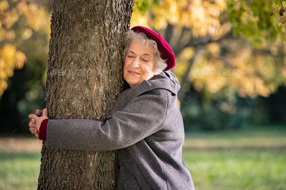Senior woman hugging tree - Stock Photo - Images