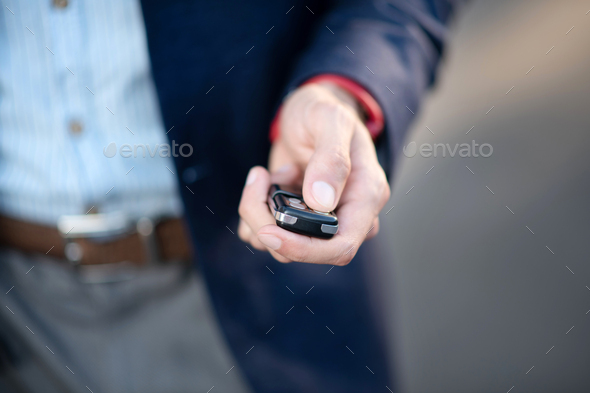 Businessman holding car keys while running late for work