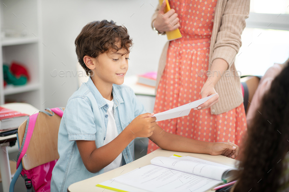 Dark-haired boy taking his test during the lesson
