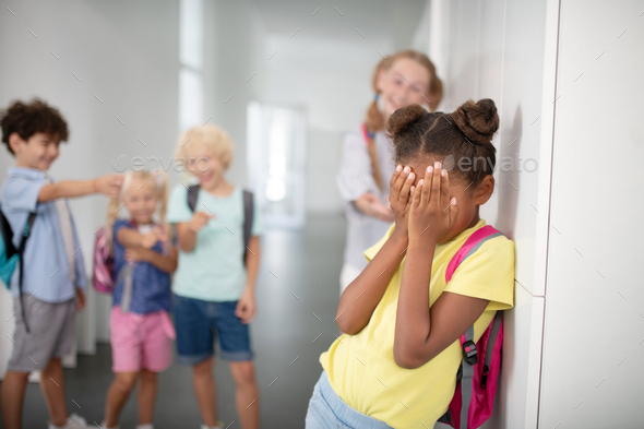 Dark-skinned girl closing her face while suffering from bullying Stock ...