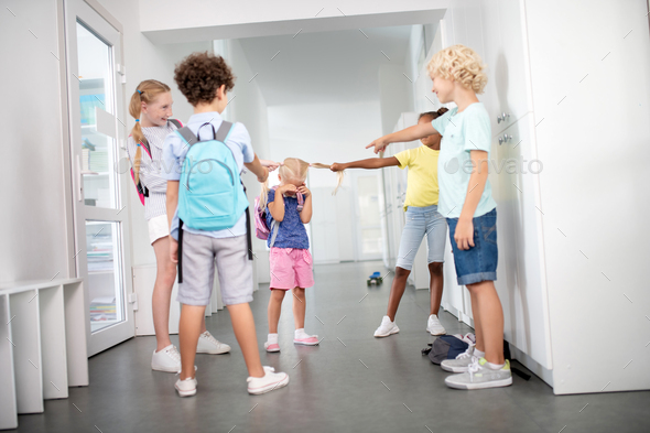Rude pupils bullying poor little girl in the corridor