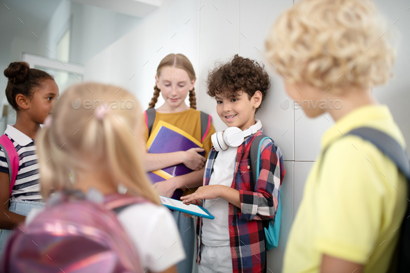 Boys and girls standing near lockers and talking while having break