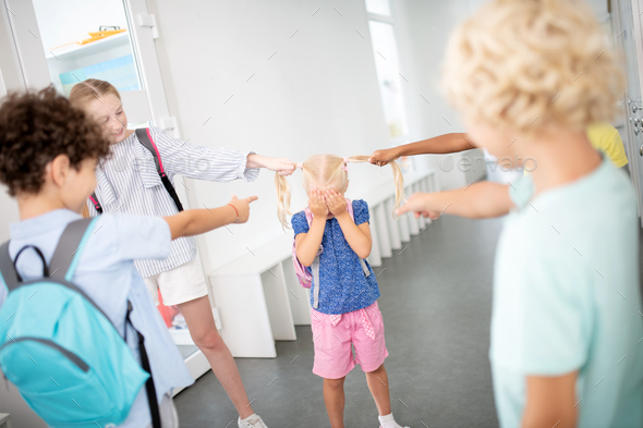 Rude children pulling hair of poor little girl Stock Photo by Zinkevych_D