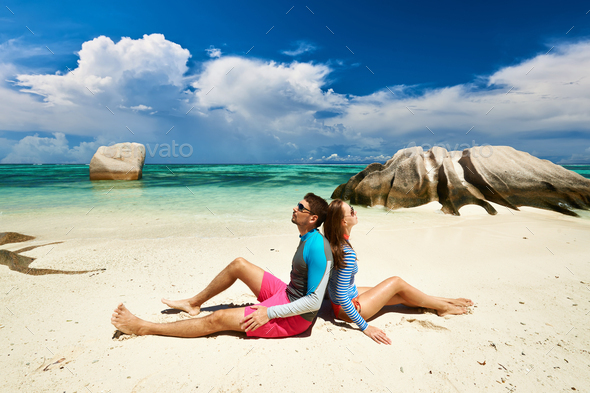 Couple at tropical beach wearing rash guard