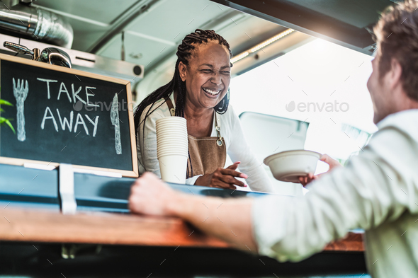 Female food truck owner serving meal to male customer - Modern business and take away concept