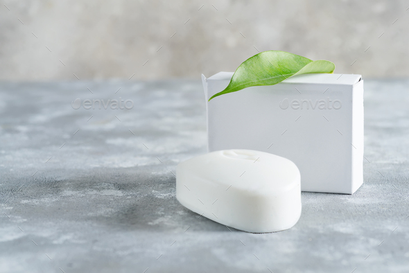 White soap for hand with leaf at stone background. Mock up for logo and text