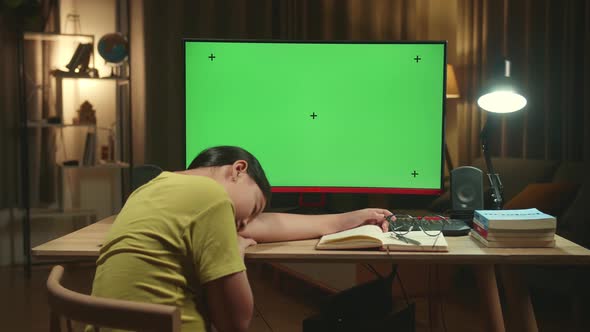 Girl Sleeping On The Table While Distance Learning With Mock Up Computer Green Screen From Home alt