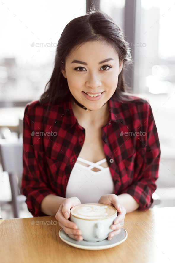 attractive asian girl drinking coffee in cafe, coffee break concept