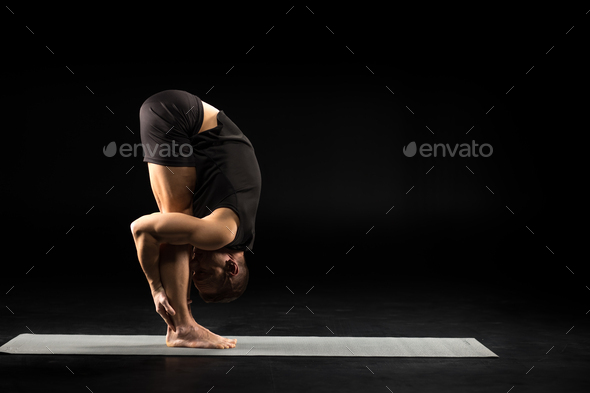 Side view of athletic man practicing yoga in Uttanasana or The Standing Forward Bend Pose isolated