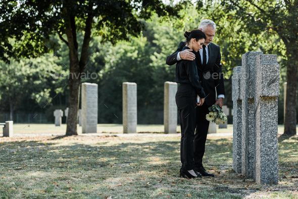 upset man hugging frustrated woman in cemetery Stock Photo by ...