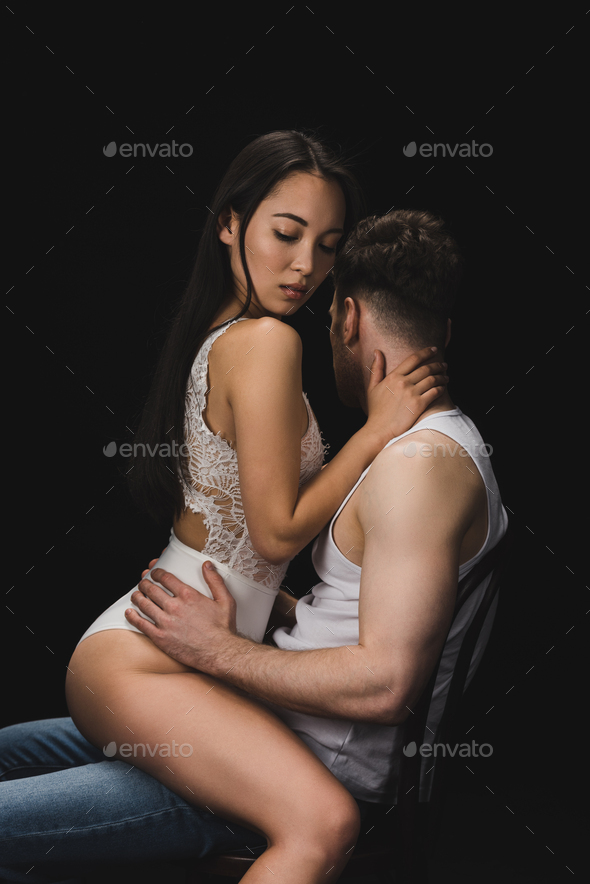 beautiful asian woman in white lingerie sitting on knees of boyfriend and  looking down isolated on Stock Photo by LightFieldStudios
