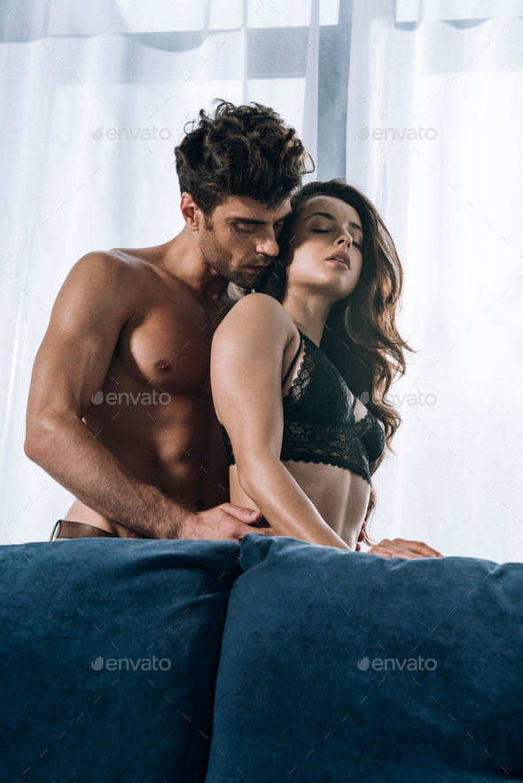 handsome, shirtless man kissing sexy woman in black lace bra Stock Photo by  LightFieldStudios