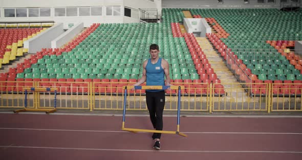 Sportsman Preparing Hurdle for Workout alt