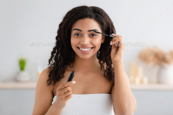 Woman getting ready for work, doing morning makeup routine in bathroom at home