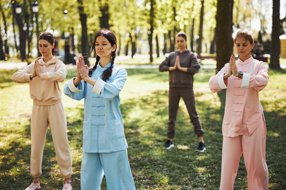 Woman holding a tai chi pose in autumnal park stock photo