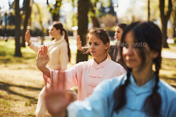 Females pushing arm forward with open palm during tai chi
