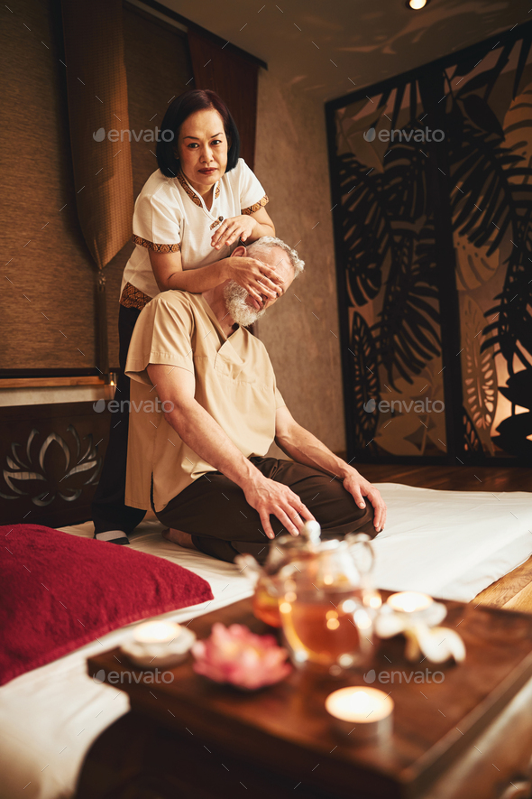 Massage relax studio. Woman having her neck massaged by a