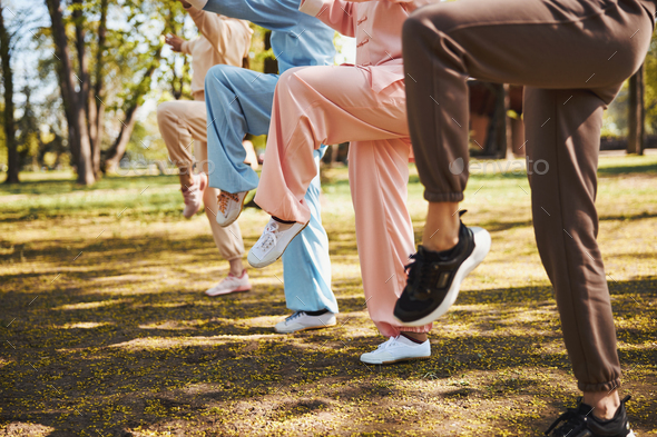 Raised legs of four people, doing exercise in park - Stock Photo - Images