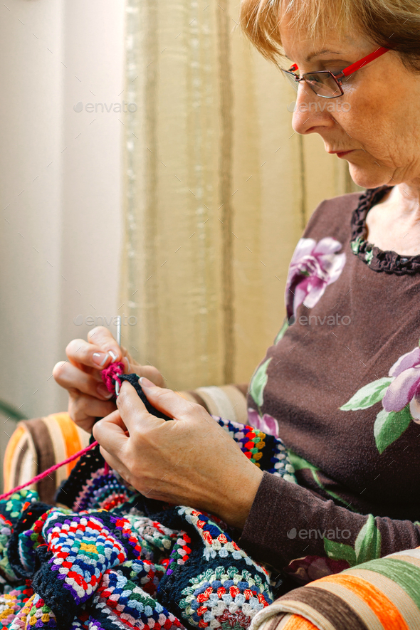 Portrait of woman knitting a vintage wool quilt