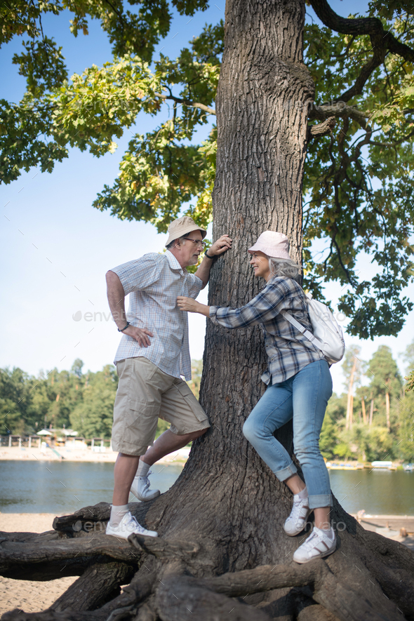 Couple standing near huge tree walking near river