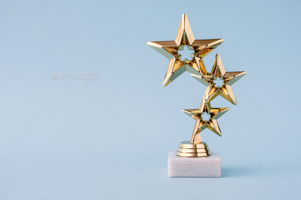 Three star awards for leader and ranking. Golden shiny prize on a pastel  blue background. Stock Photo by sergign