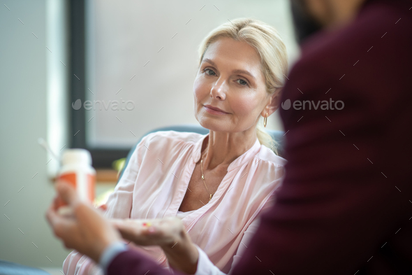 Woman suffering from anxiety sitting near psychologist