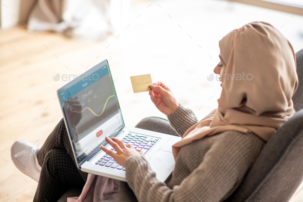 Close up of woman using her gold card to make some purchase online