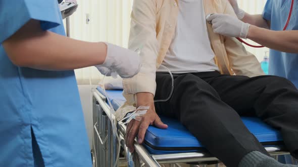 Asian medical team doctors nurse examining and checking Asian elderly male patient alt