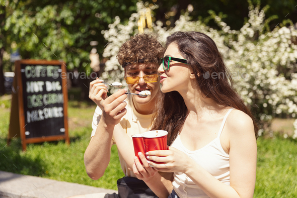 Happy attractive young couple romantically eating a fresh pizza outdoors - Stock Photo - Images
