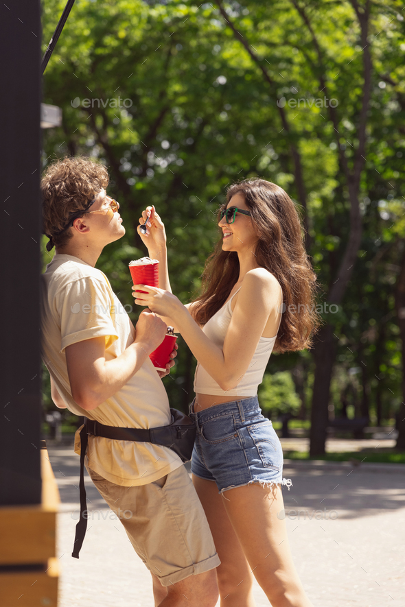 Happy attractive young couple romantically eating a fresh pizza outdoors - Stock Photo - Images