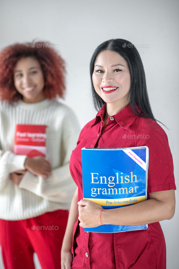 Asian dark-haired woman holding English grammar book