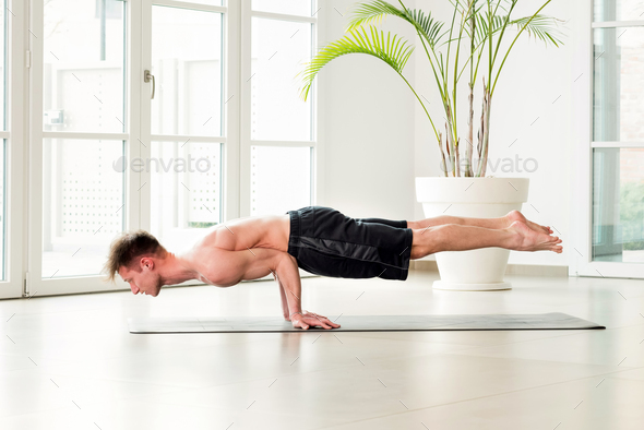 Athletic sporty man doing a yoga balance pose Stock Photo by Photology75