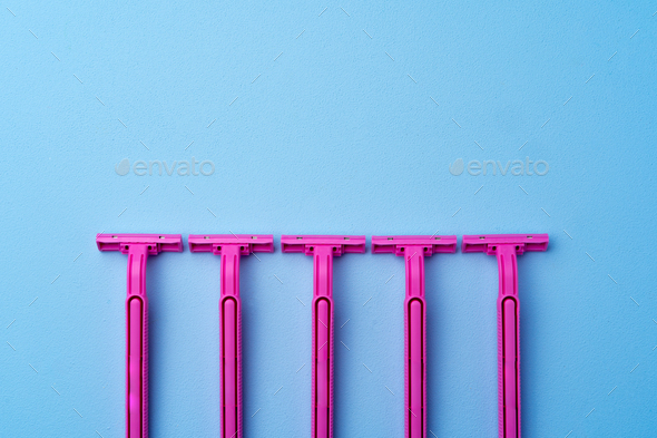Set of disposable razors for women on blue background