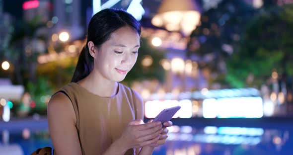 Woman use of mobile phone in the city at night alt