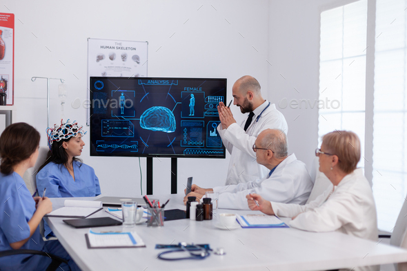 Neurologist showing digital radiography to medical coworkers analysing brain illness
