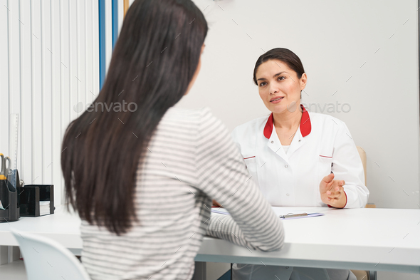 Delighted young medical worker consulting her patient