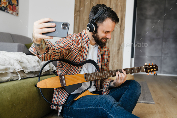 Smiling mid aged brunette bearded man playing - Stock Photo - Images